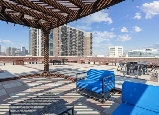 3200 Main rooftop patio with blue couches and view of the Downtown Dallas skyline in the background | Deep Ellum Lofts in Dallas, TX