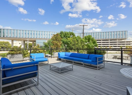 Rooftop deck with blue couches and a coffee table | Deep Ellum Lofts in Dallas, TX