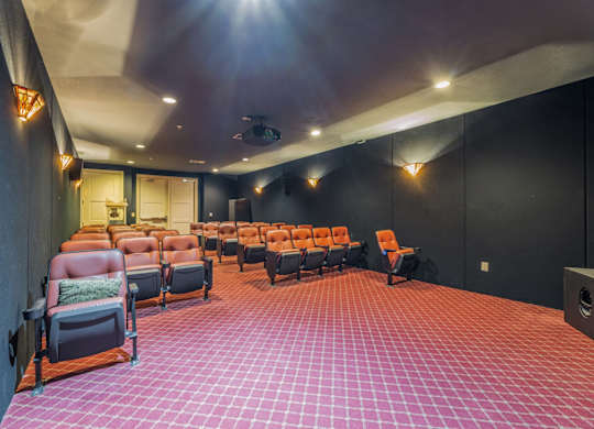 Large 35-seat theater room with selection of movies and a popcorn maker cart at Encore at Buckingham apartments in Richardson, TX