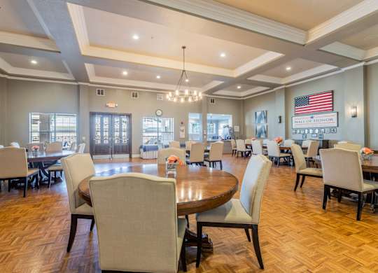 Grand ballroom with wall that has American flag and photos commemorating veterans at Encore at Buckingham apartments in Richardson, TX