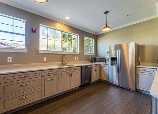 Ballroom kitchen with stainless steel appliances and ample counterspace at Encore at Buckingham apartments in Richardson, TX