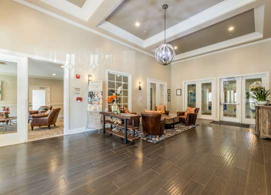 Leasing office interior waiting area with a table and chairs at Encore at Buckingham apartments in Richardson, TX