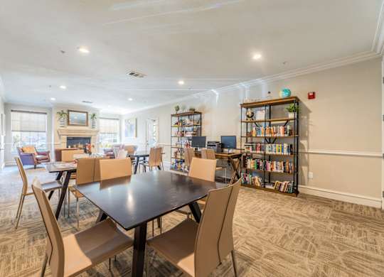 Game room and library with a selection of books, a computer center, and board games at Encore at Buckingham apartments in Richardson, TX