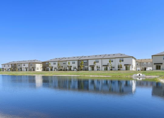 a lake sits in front of a row of townhomes at Beacon at Arbours, Ruskin, FL