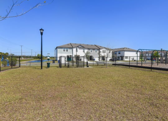 a large yard with a fence and houses in the background at Beacon at Arbours, Ruskin, Florida