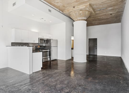 Loft kitchen and living area with polished concrete floors | Adam Hats Lofts from Deep Ellum Lofts in Dallas, TX