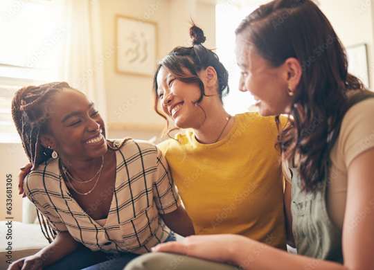 Three women are sitting closely together, sharing a moment of laughter and joy.