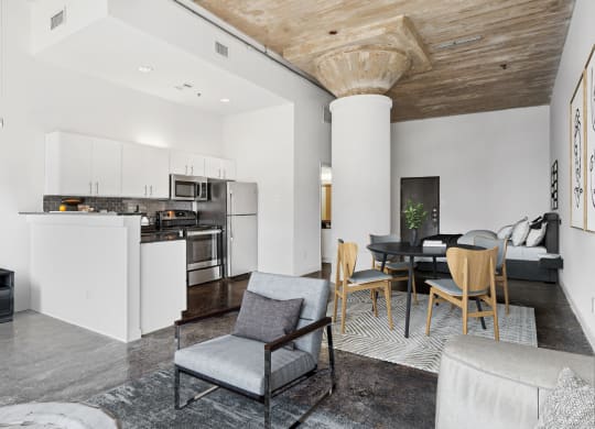 Adam Hats Lofts virtually staged loft living area and kitchen with stainless steel appliances | Deep Ellum Lofts in Dallas, TX