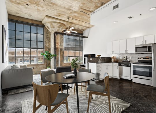 Adam Hats Lofts virtually staged kitchen and living area with stainless steel appliances, beautiful pillar and large windows | Deep Ellum Lofts in Dallas, TX