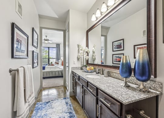 Elegant bathroom with granite countertops and modern fixtures at Allusion at West University apartments in Houston, TX
