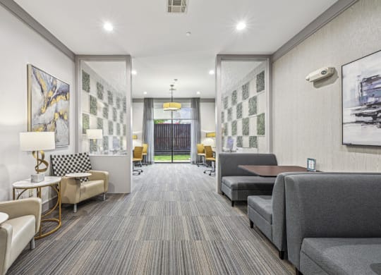 Business center with seating areas and workstations at Allusion at West University apartments in Houston, TX.