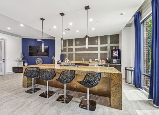 Sleek catering kitchen with a large island and bar seating at Allusion at West University apartments in Houston, TX.