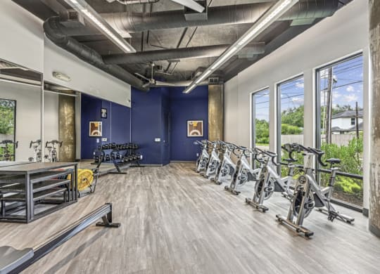 Fitness room featuring spin bikes and a variety of free weights at Allusion at West University apartments in Houston, TX