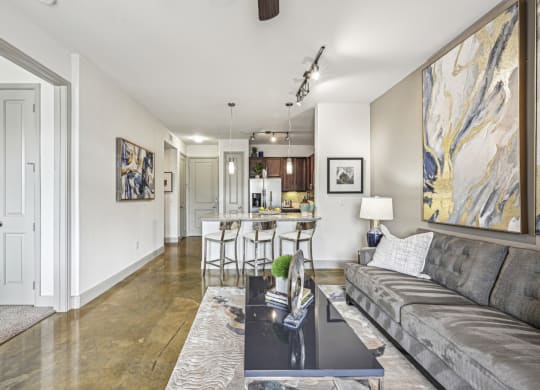 Open living space with a view into the kitchen at Allusion at West University apartments in Houston, TX