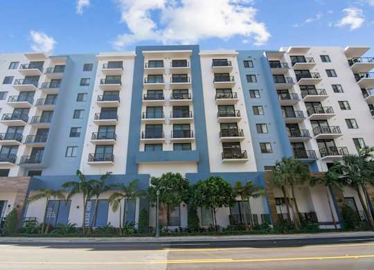 A large apartment building with balconies and doors.
