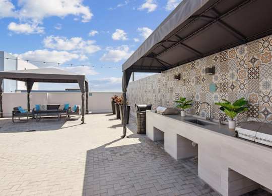 A patio with a bench and a wall with tiles.