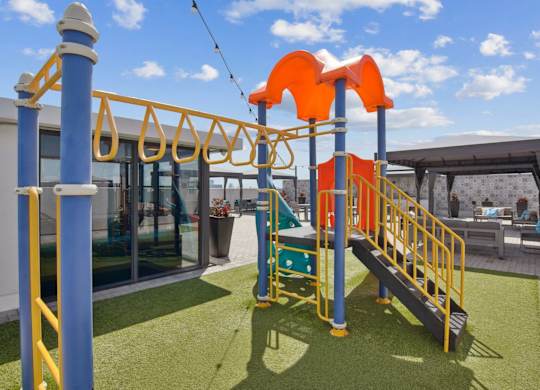 A playground with a slide and a climbing frame.