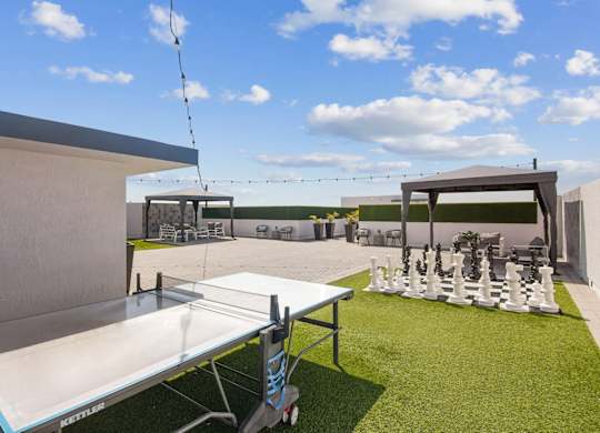 A white table tennis table is set up on a grassy area.