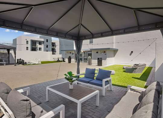 A patio with a table and chairs under a canopy.