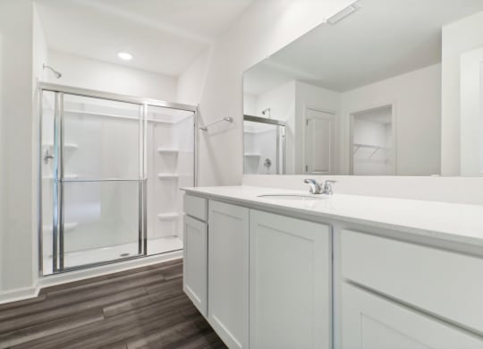 Elegant bathroom with a walk-in shower and white vanity at Beacon at Ashley River Landing in Summerville, SC
