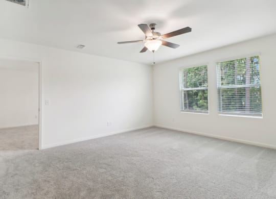 Maple master bedroom with ceiling fan and carpet flooring at Beacon at Ashley River Landing in Summerville, SC