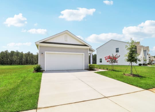 Oak front view with a white garage and a driveway at Beacon at Ashley River Landing in Summerville, SC