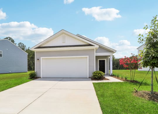 Exterior view of a single-story home with a two-car garage at Beacon at Ashley River Landing in Summerville, SC