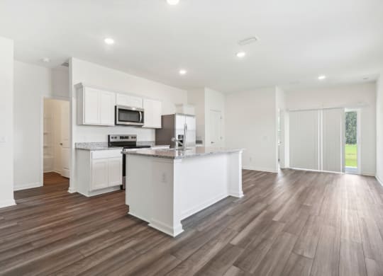 Oak open kitchen and living room with white cabinets and a counter top at Beacon at Ashley River Landing in Summerville, SC