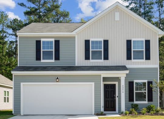 Front view of the Redbud floor plan house painted in a blue and off-white color scheme at Beacon at Ashley River Landing in Summerville, SC