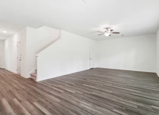 Sycamore living room with white walls connected to the stairs at Beacon at Ashley River Landing in Summerville, SC