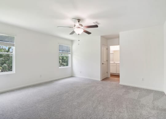 Sycamore master bedroom with ceiling fan and carpet flooring at Beacon at Ashley River Landing in Summerville, SC
