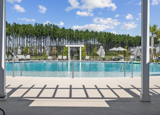 a swimming pool with a white archway and trees in the background at Beacon at Ashley River Landing, Summerville, SC