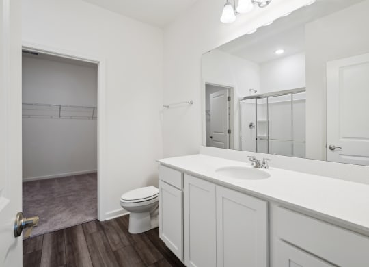 a bathroom with a toilet sink and mirror at Beacon at Bunton Creek, Texas