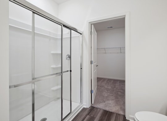 a bathroom with white walls and a glass shower stall at Beacon at Meridian, San Antonio, 78245