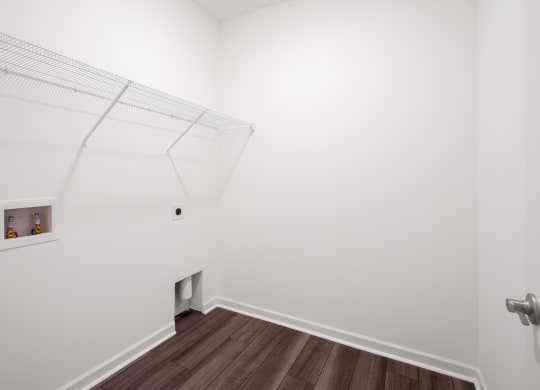 a walkin closet with white walls and a wooden floor at Beacon at Meridian, Texas