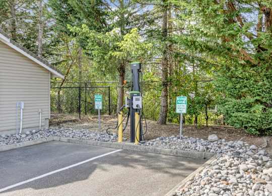 A charging station for electric vehicles with trees in the background at Abbey Rowe Apartments in Olympia, WA