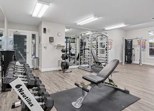 A gym with weights and strength training machines at Abbey Rowe Apartments in Olympia, WA