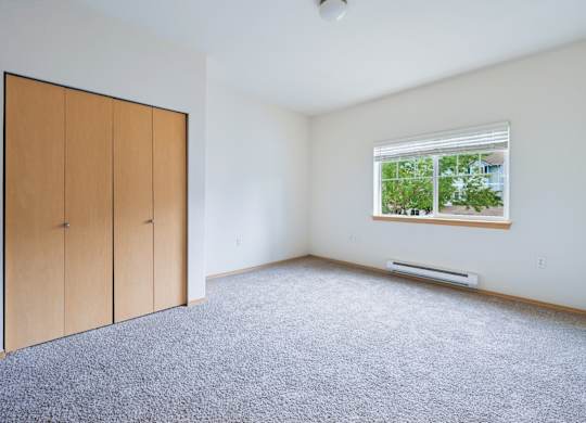 Soho bedroom with a window and a carpeted floor at Abbey Rowe Apartments in Olympia, WA