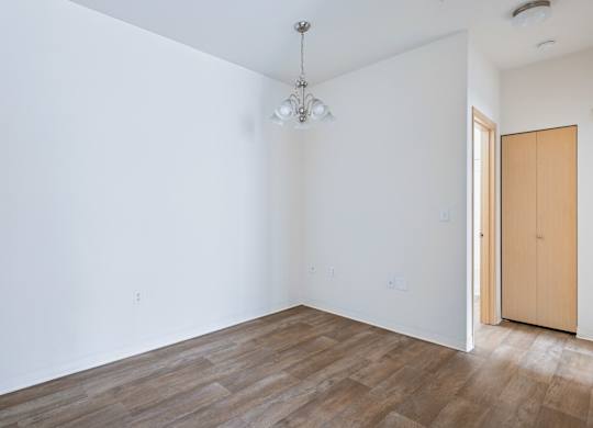 Soho dining room with a wooden floor and a ceiling light at Abbey Rowe Apartments in Olympia, WA