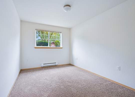 York bedroom with a window and a carpeted floor at Abbey Rowe Apartments in Olympia, WA