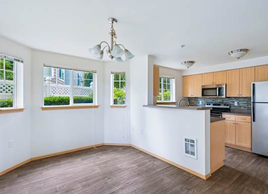 York dining room and kitchen with four windows and wood cabinets at Abbey Rowe Apartments in Olympia, WA