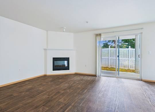 Spacious York living room with a fireplace and sliding glass doors at Abbey Rowe Apartments in Olympia, WA