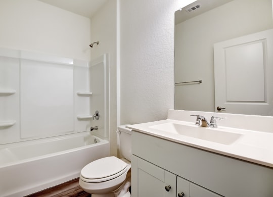 a bathroom with white cabinets, a mirror and white walls