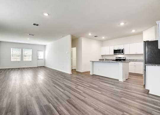 a kitchen and living room with hardwood floors and white walls at Beacon at Meridian, San Antonio Texas