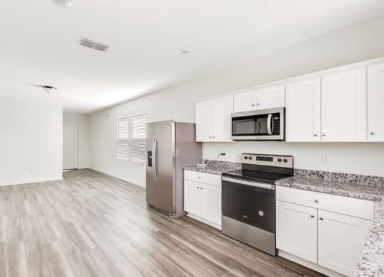 a kitchen with white cabinets and stainless steel appliances