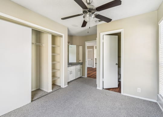 Modern bedroom with carpet and ceiling fan at Bandera Crossing apartments in San Antonio, TX