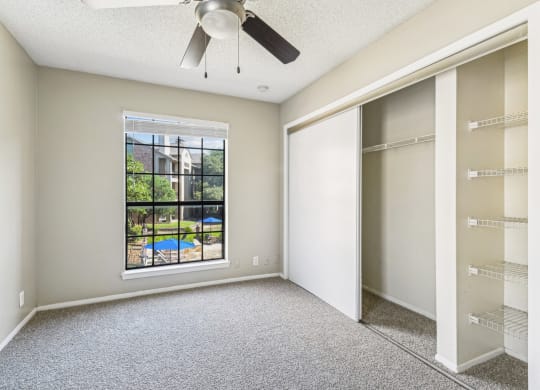 Bright bedroom with a big window at Bandera Crossing apartments in San Antonio, TX
