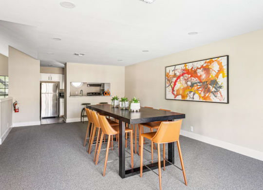 Clubhouse dining area with tall table and seats next to kitchen at Bandera Crossing apartments in San Antonio, TX