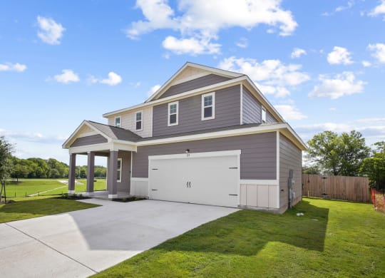 a home with a gray siding and a white garage door at Beacon at Bunton Creek, Kyle, TX 78640