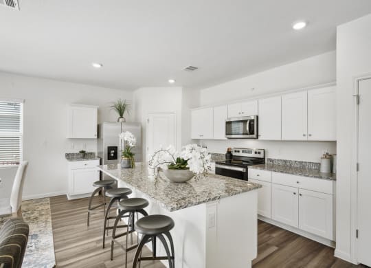 a kitchen with white cabinets and a granite counter top at Beacon at Bunton Creek, Texas